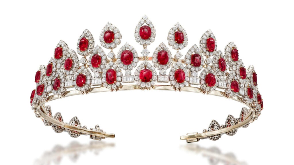 Designed as a convertible jewel, this piece forms either a necklace or a tiara. It has a fringe of oval- and cushion-cut Burmese rubies, each surrounded by old European- and brilliant-cut diamond drops, joined by trios of baguette-cut diamonds by Sotheby's image