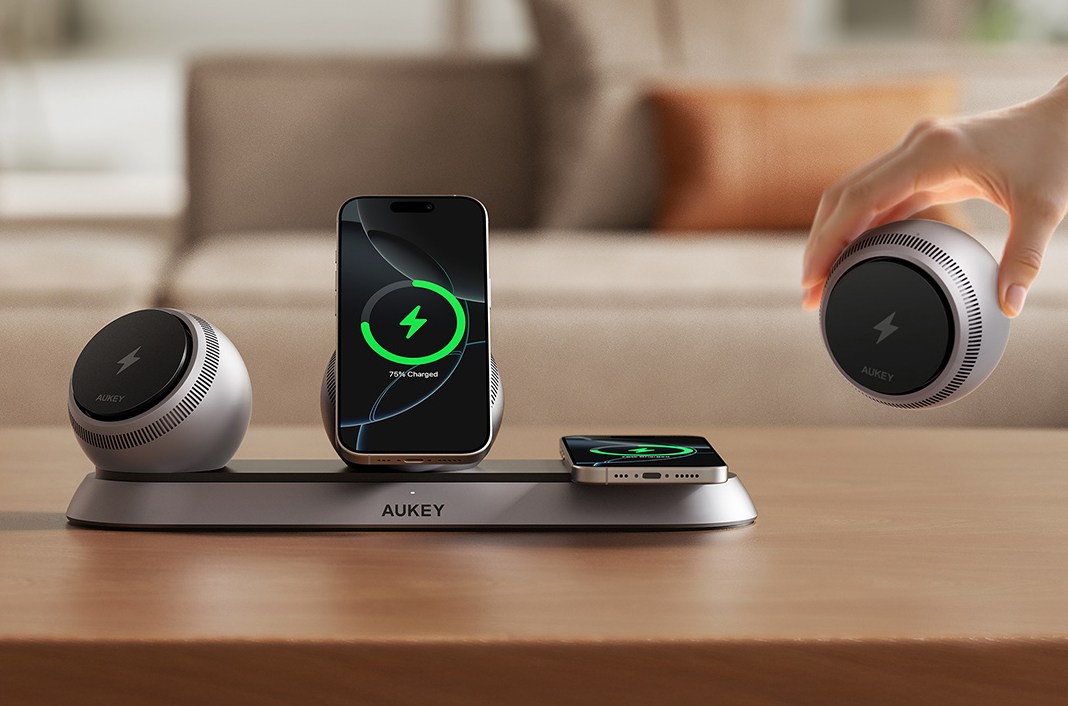 A hand removing a charger from Aukey’s MagFusion Ark charging station.