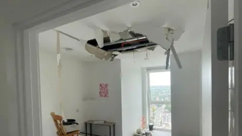 Current and past residents of The Fold A ceiling in a flat has collapsed, with plaster and insulation hanging down into a bright living space.