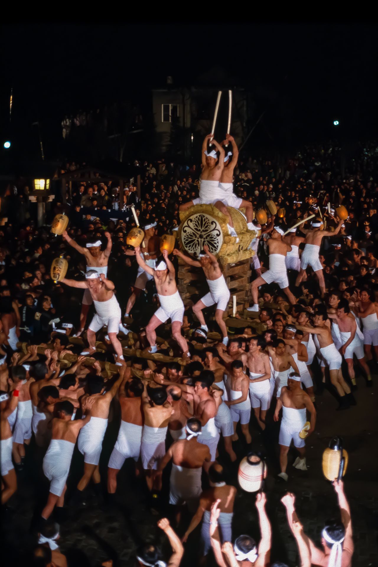 In the drum procession, bearers carry the huge drum, with two men astride and two others pounding out the matsuri rhythm. (© Haga Library)