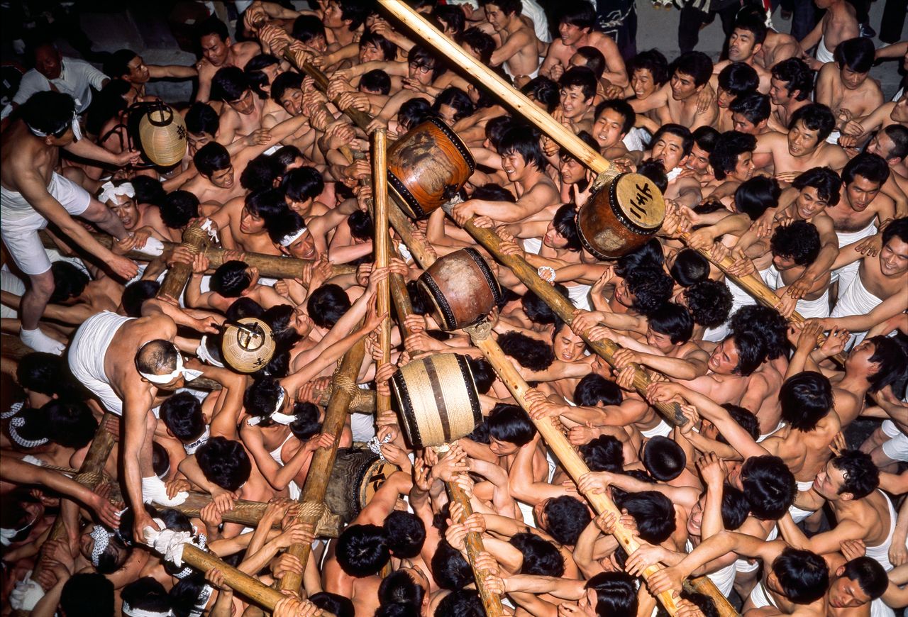 Men scramble over each other to approach the okoshidaiko. (© Haga Library)