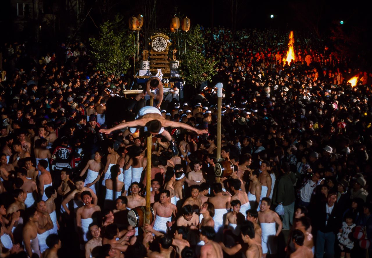 Festival participants perform an acrobatic “dragonfly” pose. (© Haga Library)
