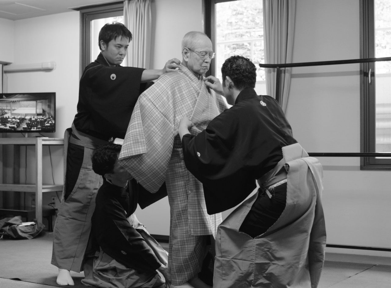 Getting dressed in a kyōgen costume is a task requiring three assistants. (© Mansaku no Kai)