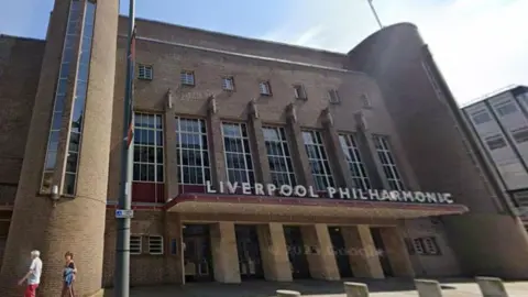 Google Exterior of the Art Deco Liverpool Philharmonic Hall. A brick building with several entrances.