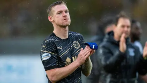 SNS Inverness Caledonian Thistle's Billy Mckay claps his hands as he leaves a pitch while it pours with rain.