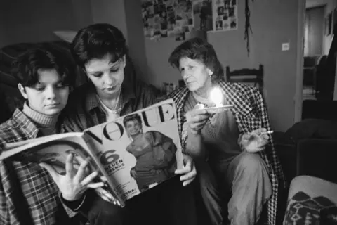 David Turnley/Corbis/VCG via Getty Images Woman Looking at Vogue Magazine