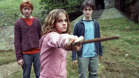 Getty Images Rupert Grint, Emma Watson, and Daniel Radcliffe (from left to right) during a scene outdoors in Harry Potter And The Prisoner of Azkaban