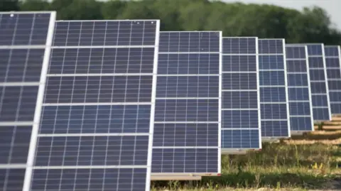 PA A row of solar panels mounted on agricultural land.