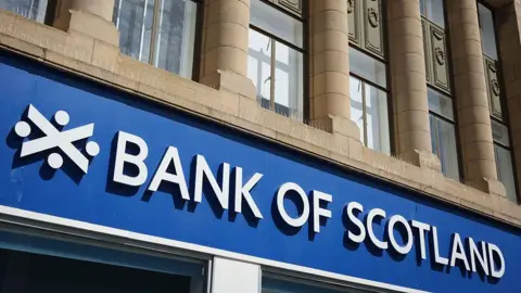 Getty Images Bank of Scotland sign on a building. The words are in white on a blue background and there is also the Bank of Scotland symbol.