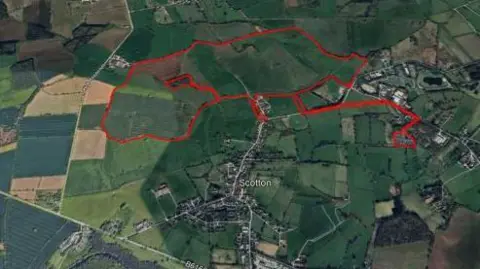 North Yorkshire Council An aerial view of fields and villages with a red outline showing the border of the proposed site.