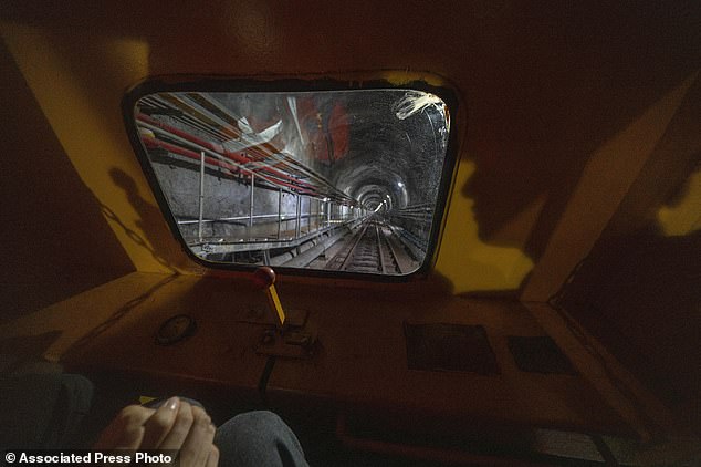 Visitors take a train ride to visit the cosmic detector located deep underground. The orb-shaped structure is filled with a liquid designed to emit light when neutrinos pass through