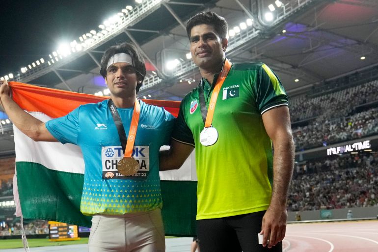 Gold medalist Neeraj Chopra, of India, and silver medalist Arshad Nadeem, of Pakistan, right, pose after finishing the Men's javelin throw final during the World Athletics Championships in Budapest, Hungary, Sunday, Aug. 27, 2023. (AP Photo/Matthias Schrader)