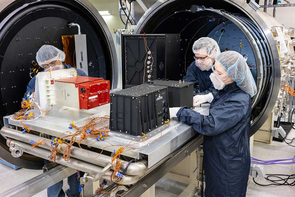 From left, engineering technologist Adolfo Salazar, systems engineer Sean Walker and systems engineer Lauren Ratliff prepare sensors from the next generation of detectors to undergo thermal vacuum testing at Sandia. (Photo by Bret Latter) Click on the thumbnail for a high-resolution image.