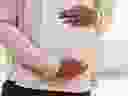 Woman holding pregnant belly.