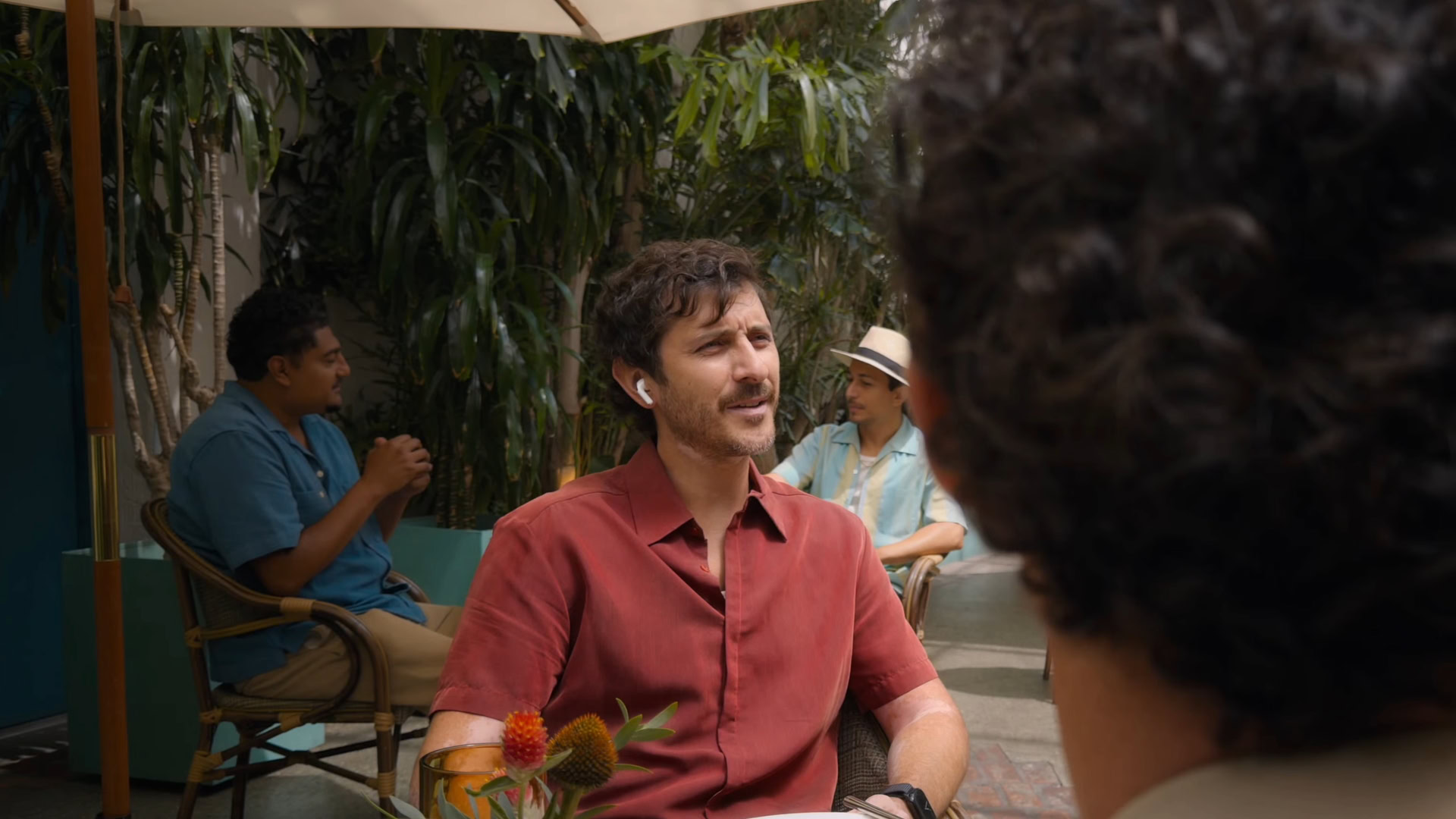 Man wearing AirPods Pro 4 talking to another person