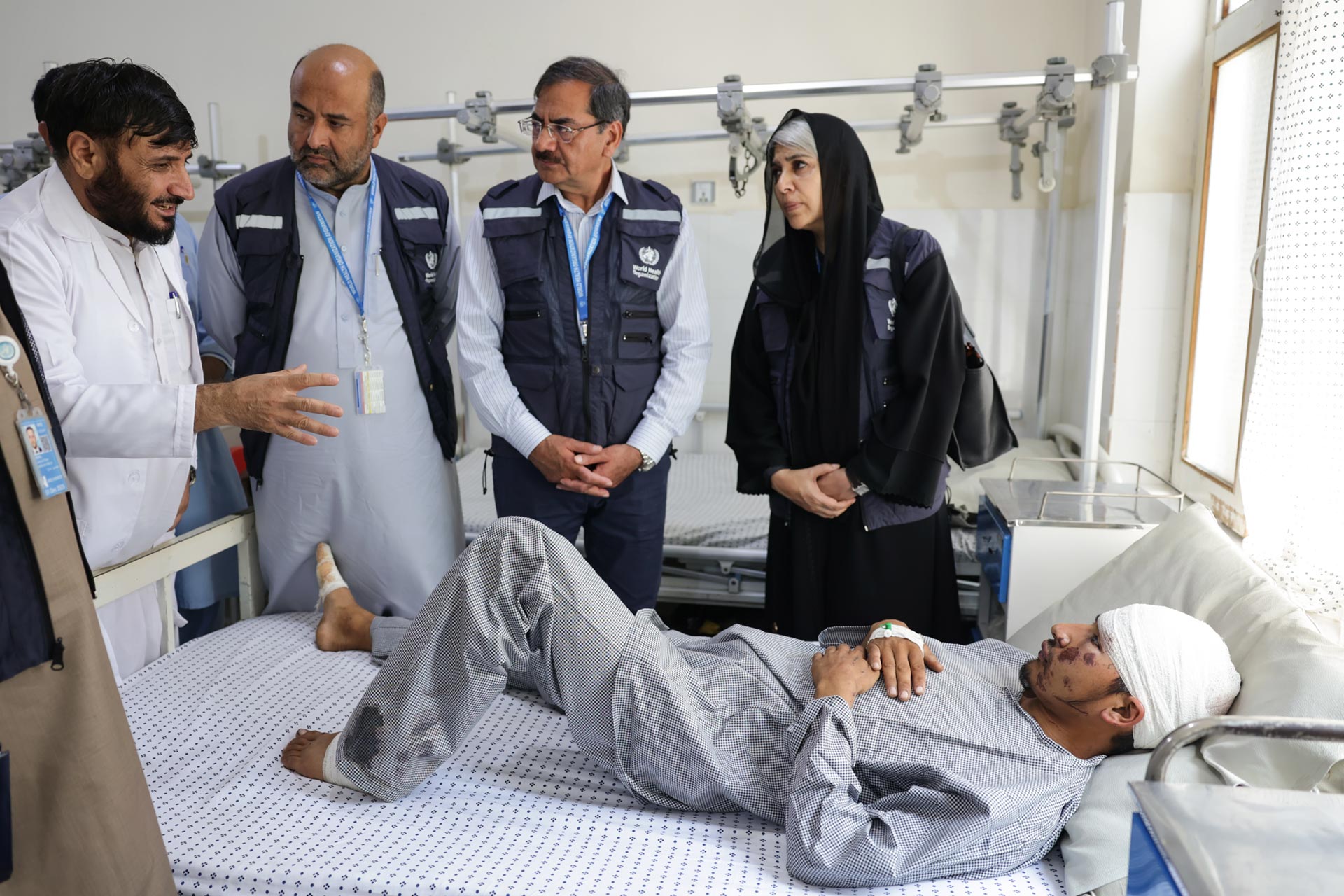 The Deputy WHO Representative, along with other WHO staff, assessing the condition of a patient injured in the Kunar earthquake at Asadabad Provincial Hospital.