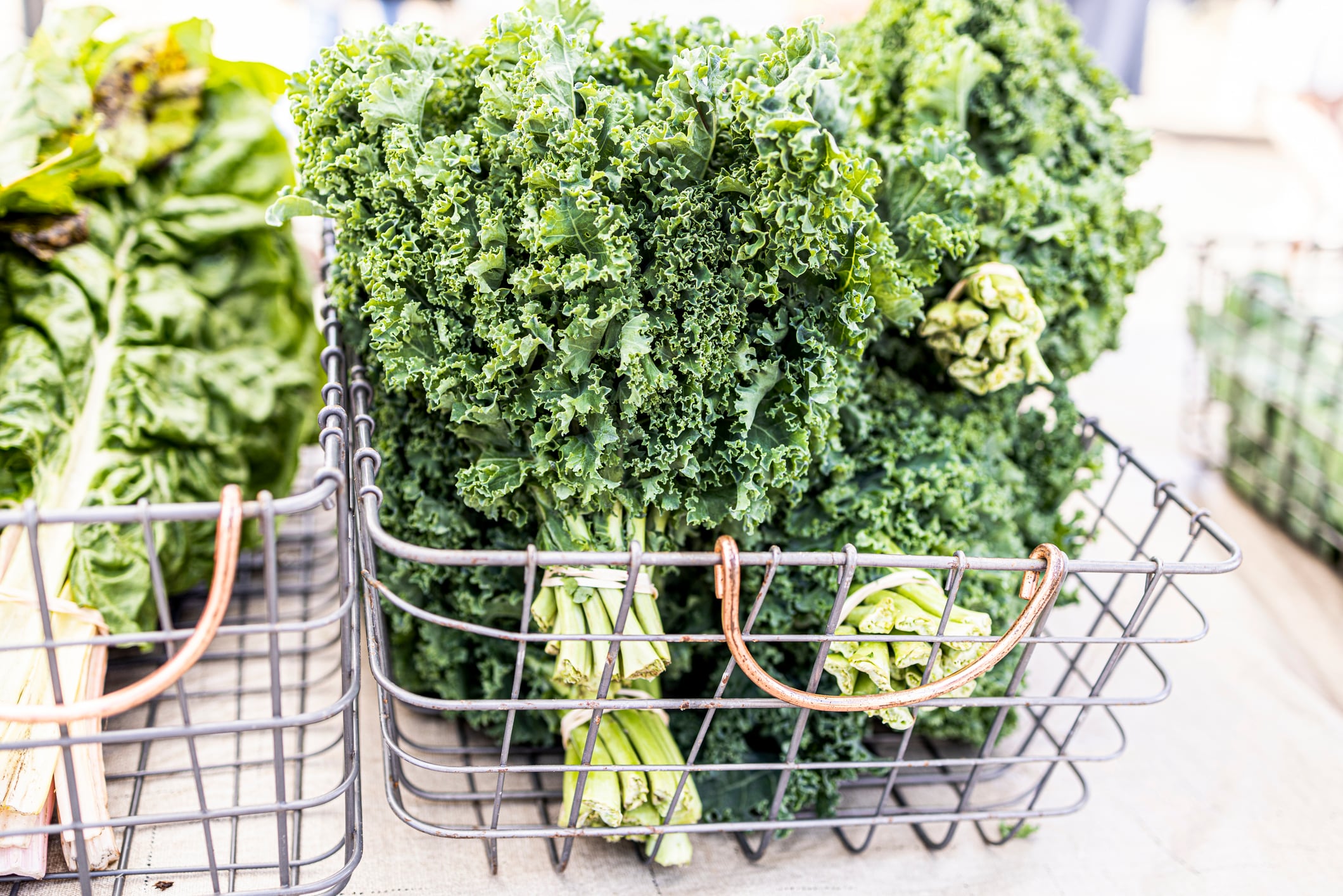 fresh bushel of green kale in metal basket on market from self-sufficiency garden