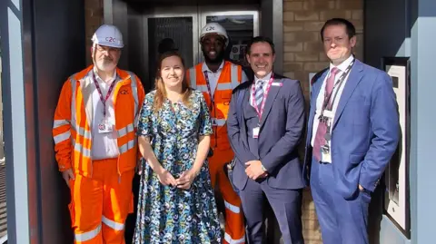 c2c Four men and one woman standing in front of the new lift