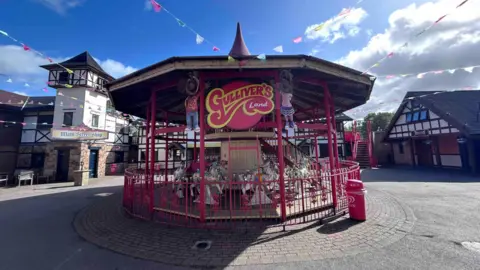 Kate Bradbrook/BBC A carousel at the centre of the entrance plaza at Gulliver's Land in Milton Keynes