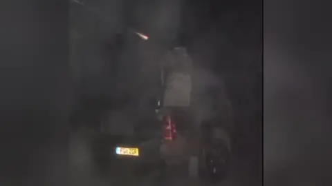 Driving Ukraine A grainy photo in which a gun is shown being fired, with a soldier on the back of the pick-up truck donated by Alistair Caldwell.