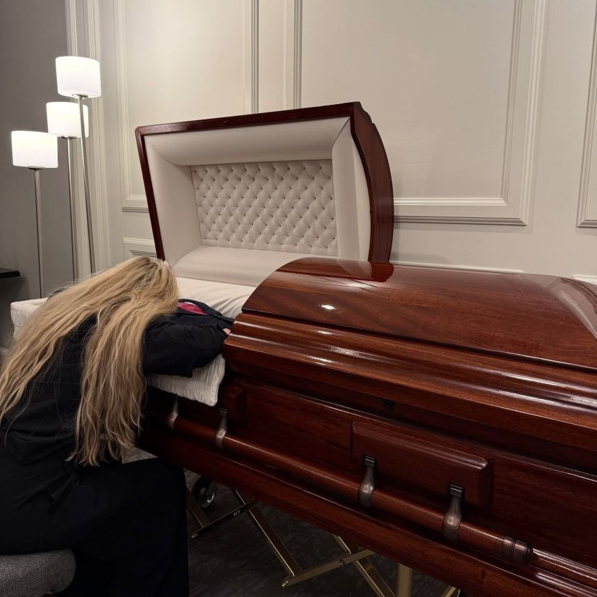 A photo from Erika Kirk's Instagram shows her beside her husband Charlie Kirk's casket.
