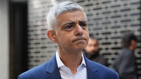 PA Media Sadiq Khan in white shirt and blue jacket