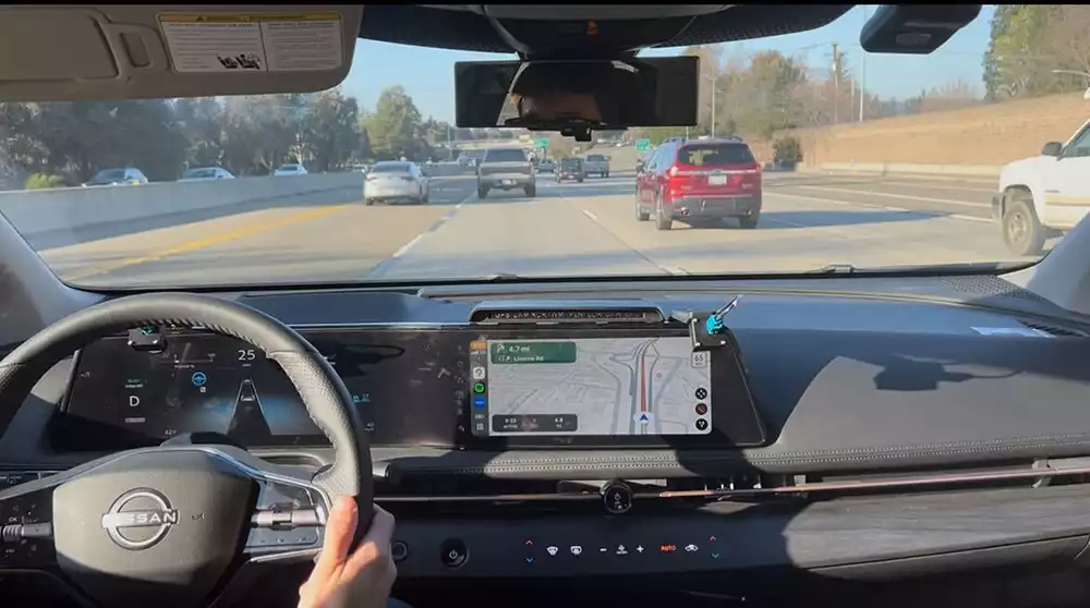 View of a highway road through the windshield of a car.