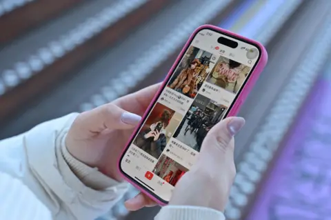 Getty Images A close-up picture of a woman holding a phone with Chinese social media app Xiaohongshu loaded on the screen