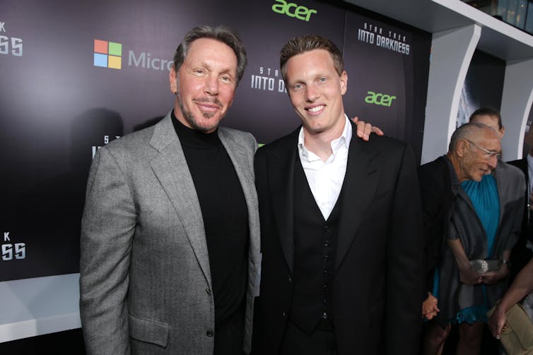 Two men, one with his arm around the shoulder of the other.