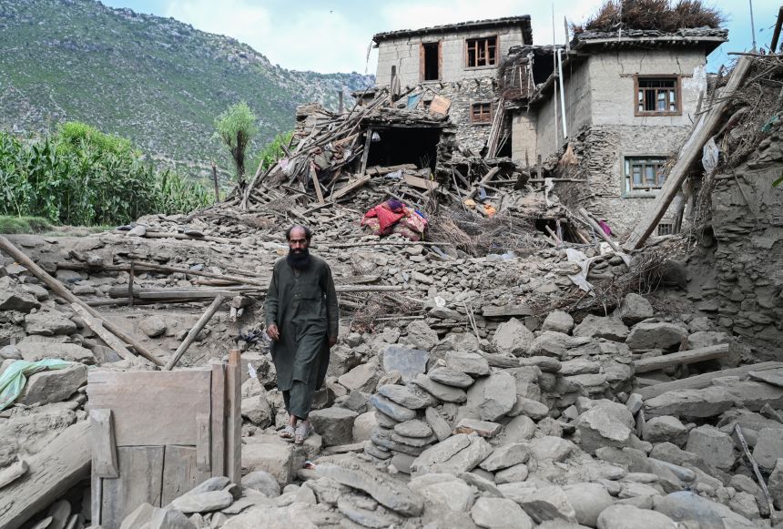 A man walks clambers over a collapsed house in the Mazar Dara village of Nurgal, on Monday. More than 5,000 homes were destroyed in Afghanistan, according to a government spokesperson.
