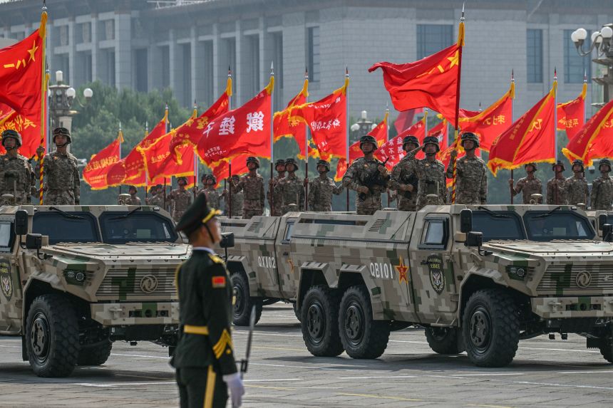 Members of the Chinese military hold flags during a military parade in Beijing's Tiananmen Square on September 3.