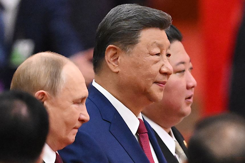 China's President Xi Jinping (center), North Korea's leader Kim Jong Un (right) and Russia's President Vladimir Putin arrive for a reception following a military parade on September 3.