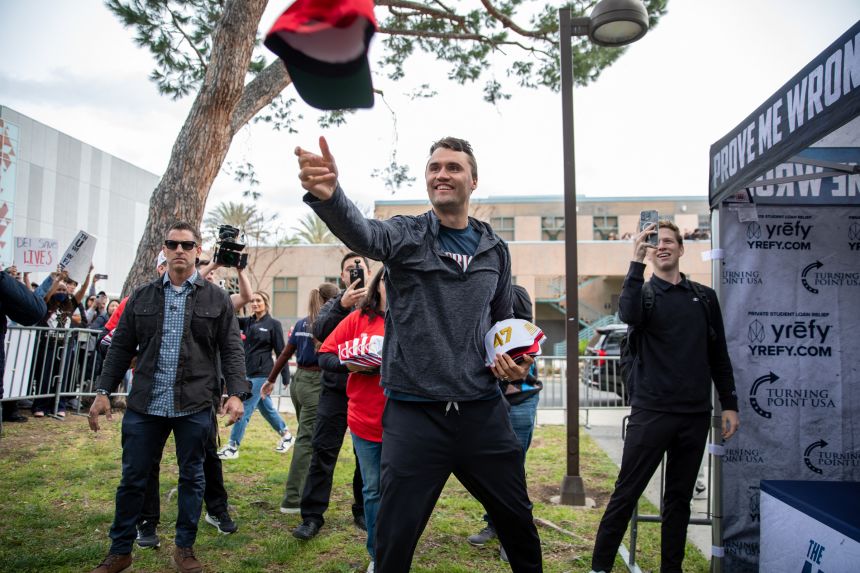 Charlie Kirk throws Trump hats into the crowd during a stop on his American Comeback Tour this spring.