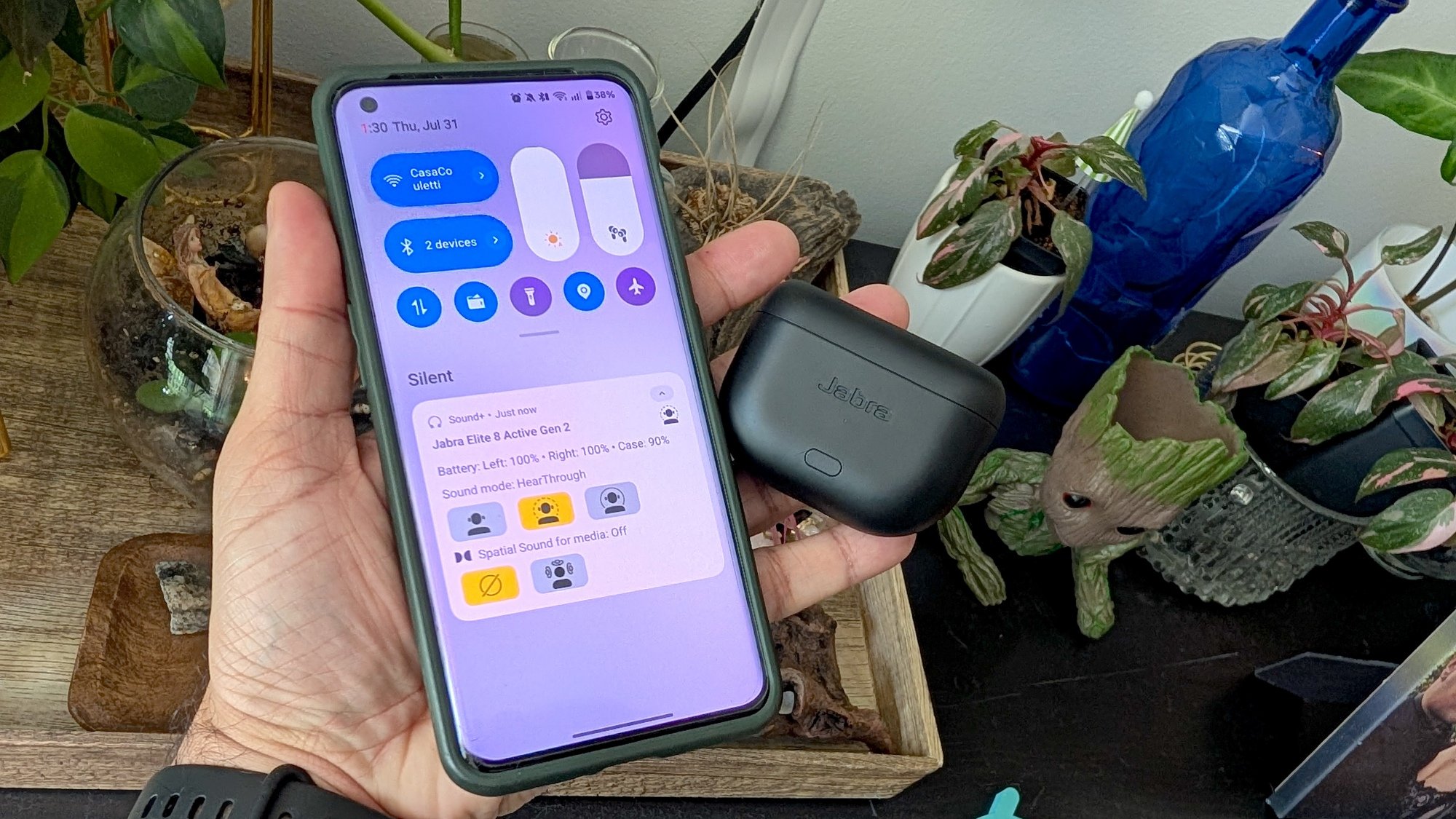 person holding earbuds and phone with shortcut widget screen