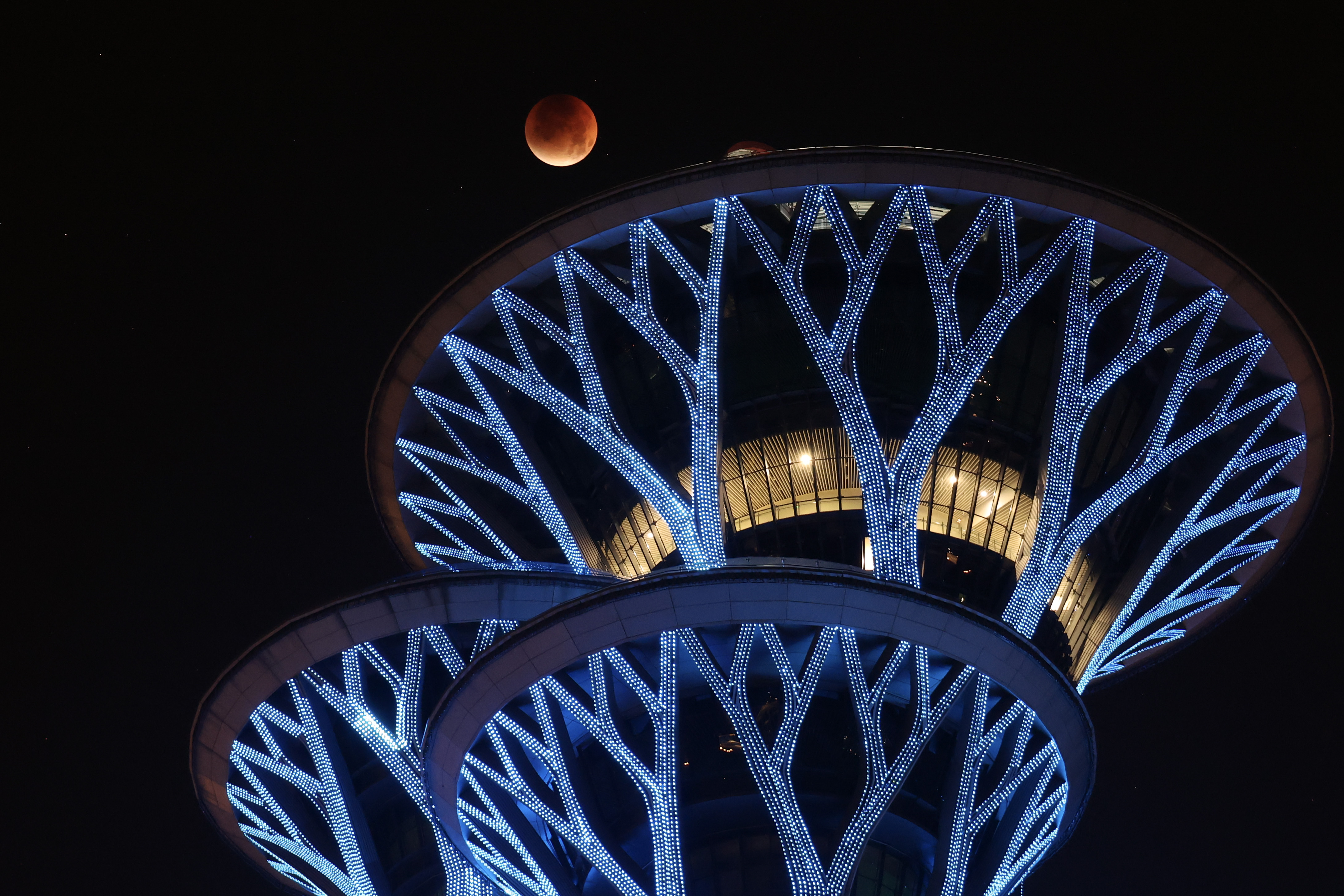 A photograph of the "blood moon" above the Olympic Park Observation Tower in Beijing, China.