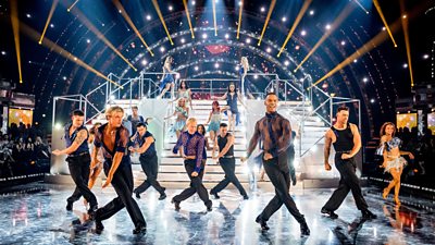 The Strictly professional dances cross their legs as they stride across the dance floor