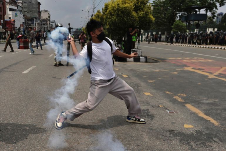 A demonstrator hurls a tear smoke shell towards members of riot police during a protest against corruption and the government’s decision to block several social media platforms, in Kathmandu, Nepal September 8, 2025. REUTERS/Navesh Chitrakar