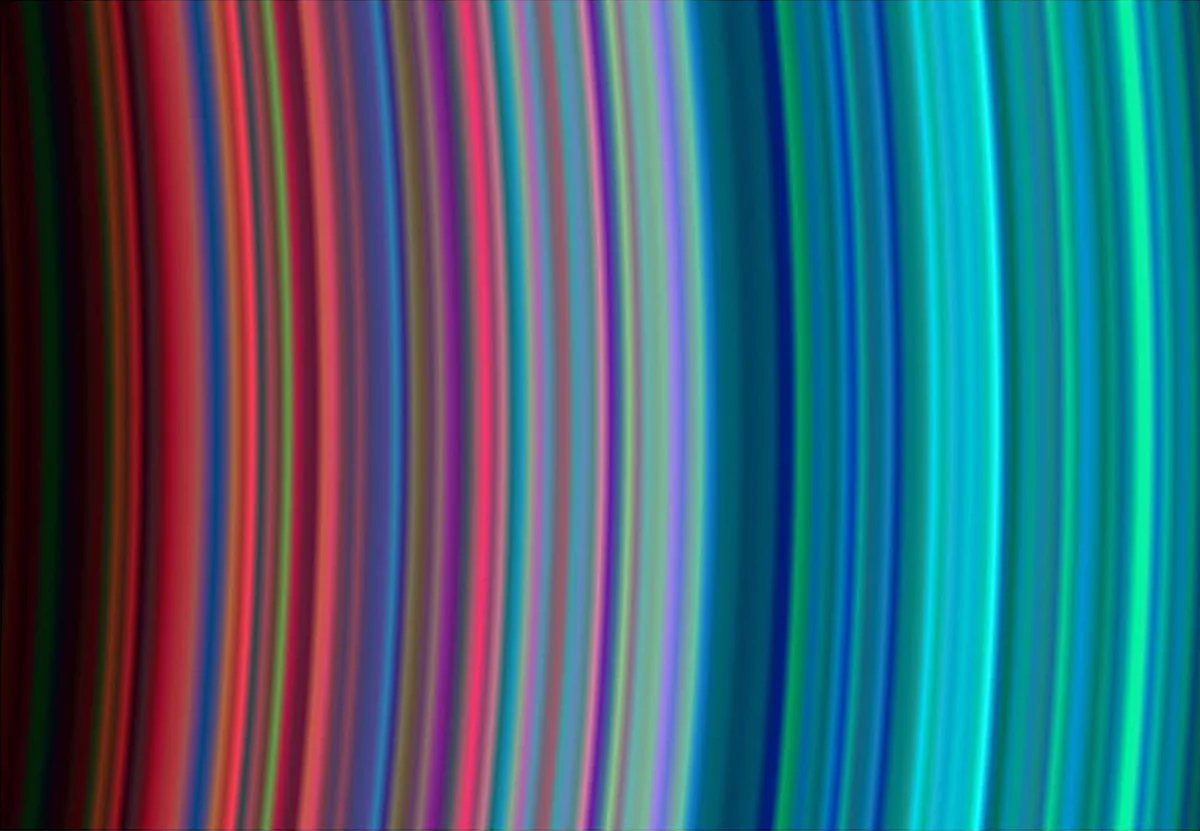 A view of Saturn's rings captured on 30 June 2004. In this image, the varying hues are caused not by Enceladus's plumes, but by of differences in their composition, as seen by the Cassini spacecraft’s Ultraviolet Imaging Spectrograph. Credit: NASA/JPL/University of Colorado