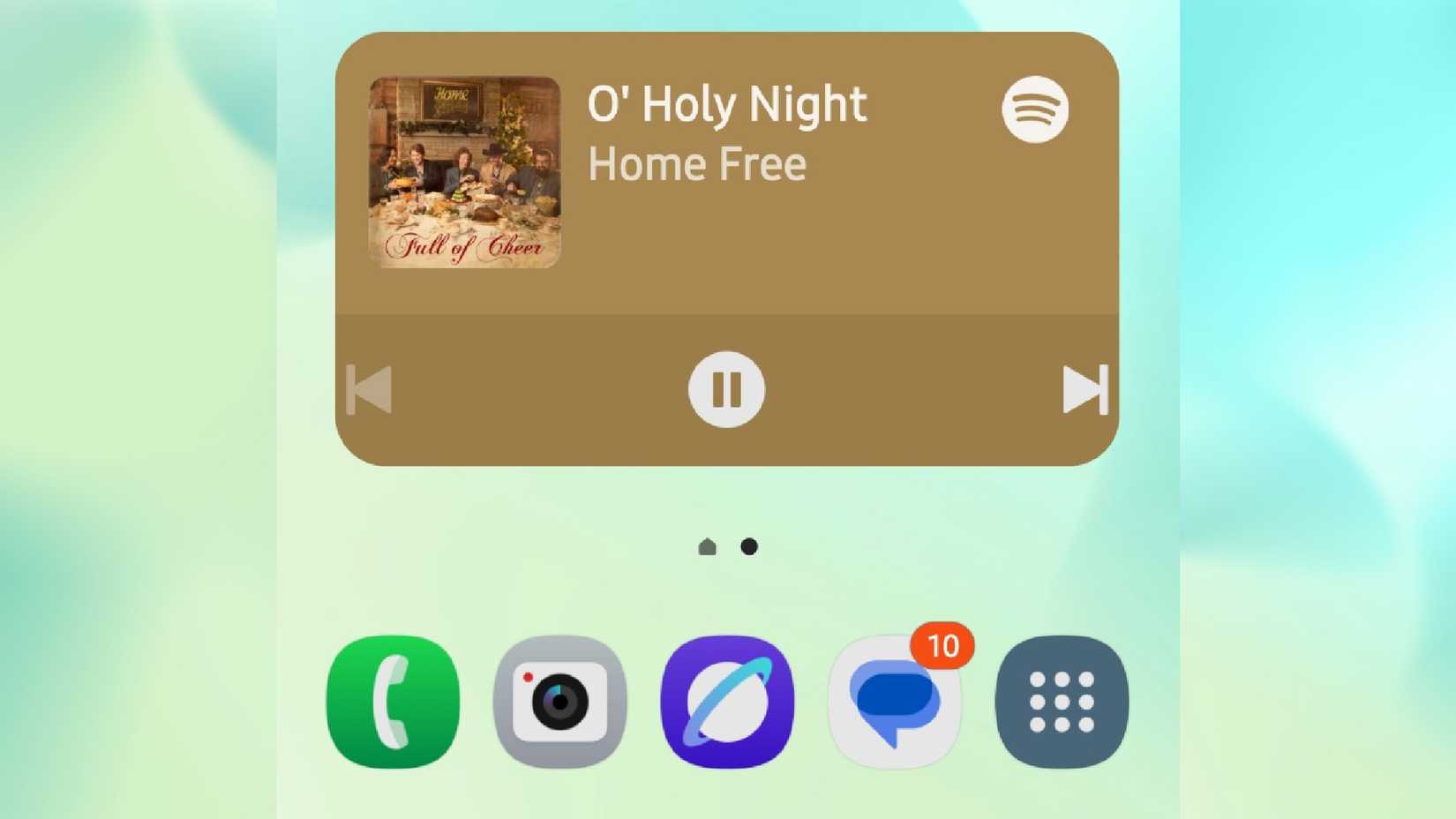 The Spotify widget showing the song O Holy Night by Home Free being played on the home screen of a phone