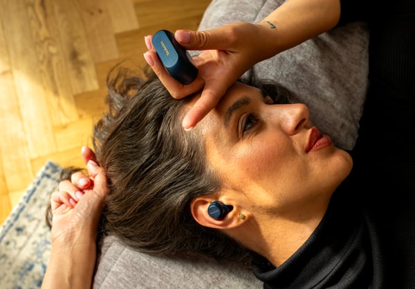 A person lying on a couch with a device on her head

AI-generated content may be incorrect.