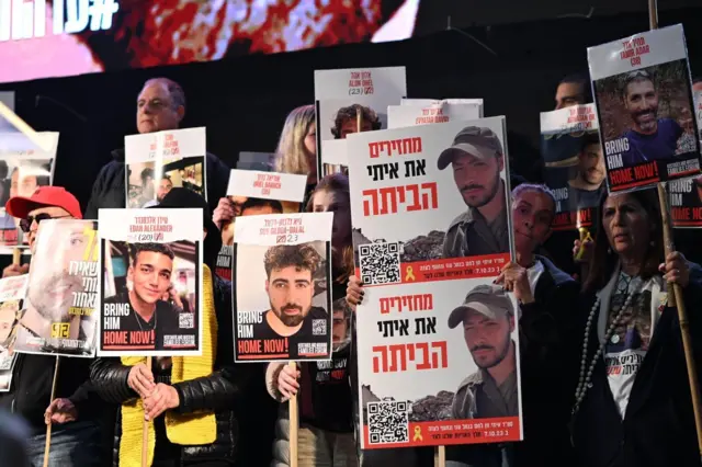 Relatives of Gaza hostages hold posters calling for them to be freed