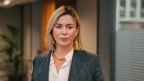 Gareth Bull Actor Eve Myles: she has blonde shoulder-length hair and is wearing a grey jacket and white shirt.