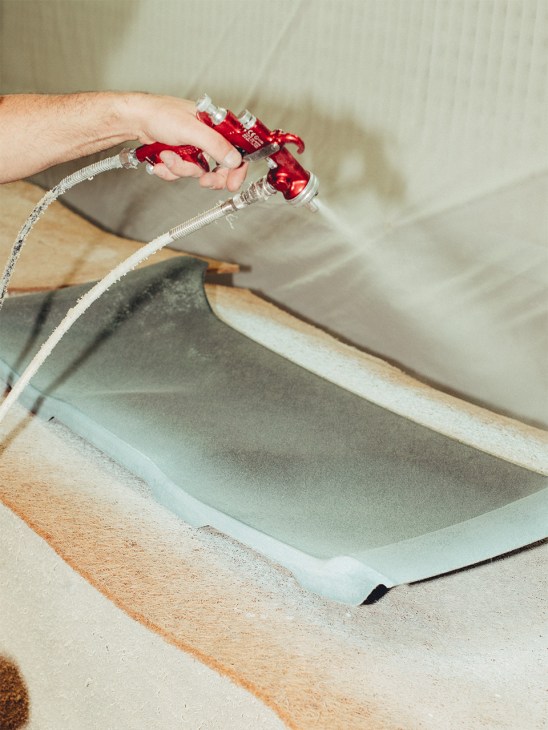 Spraying on adhesive before leather is applied at Poltrona Frau’s Montegranaro plant