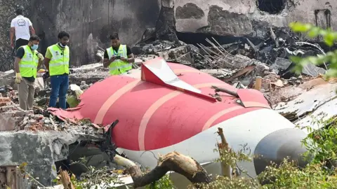 Hindustan Times via Getty Images Wreckage of the Air India plane at the crash site in Ahmedabad, India. The Air India flight, which was bound for London, crashed shortly after taking off from Ahmedabad Airport.