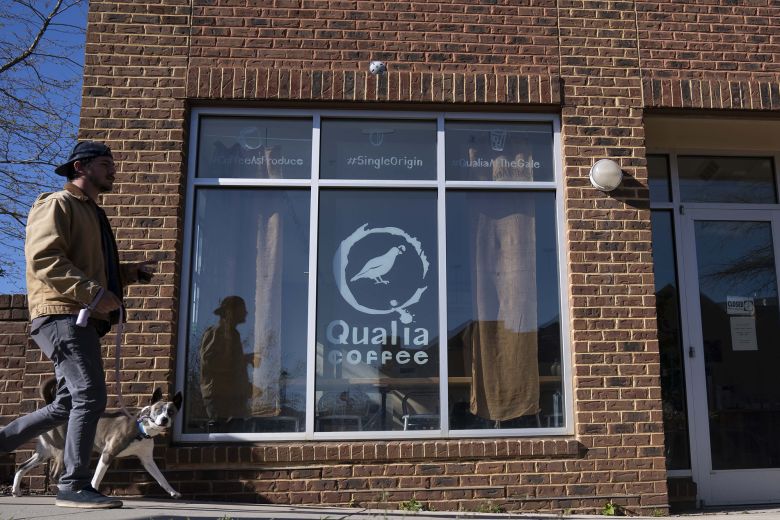 A man passes by Qualia Coffee on April 2, 2023, in Washington, DC.