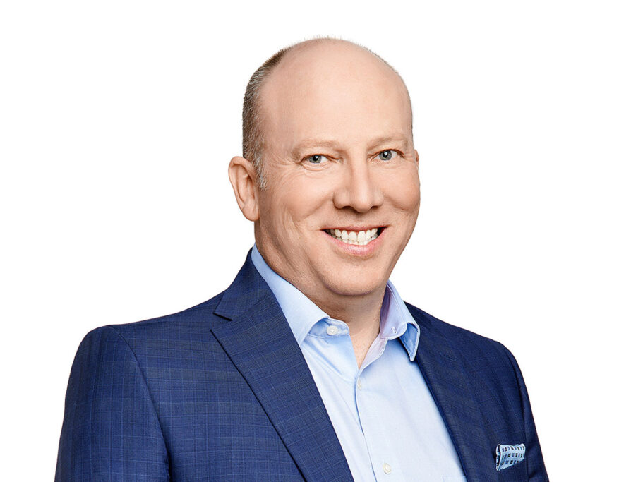 A man wearing a blue suit in front of a white background