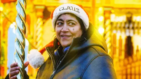 Christmas Karma A picture of Gurinder Chadha in a Santa hat