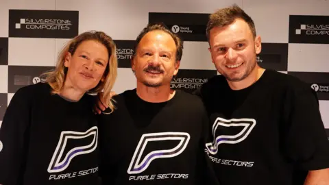 Daisy Smith Jennie Gow, Neil Cole and Chris McCarthy, standing arm in arm in front of black and white chequered branding, are in black tops with purple logos that spell out PURPLE SECTORS. 