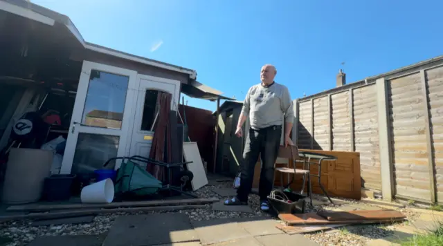 Jose standing outside his home in the back yard