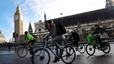 EPA Cyclists ride past Parliament during rush hour in London, on 28 October 2025